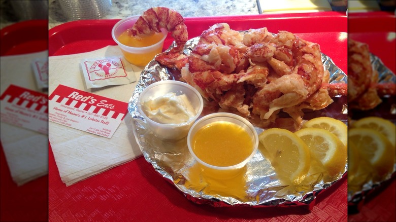 Red's Lobster roll from Red's Eats on a platter served with mayonnaise, drawn butter, and lemon slices