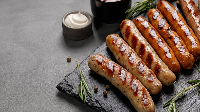 row of grilled sausages with sauces