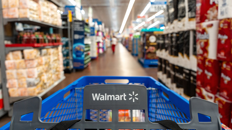 A Walmart cart heading down an aisle of the store