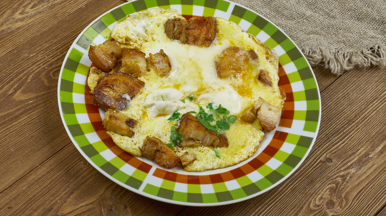 A Hangtown Fry on a gingham-patterned plate on a wood table
