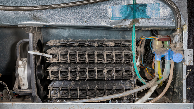 Refrigerator compressor covered in dust