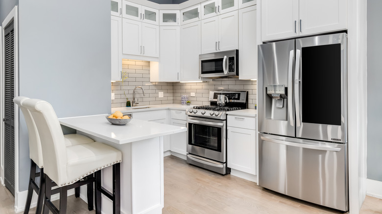 Stainless steel LG refrigerator in a bright, white modern kitchen