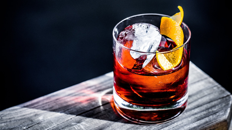 Whiskey cocktail with craft ice and lemon rind garnish