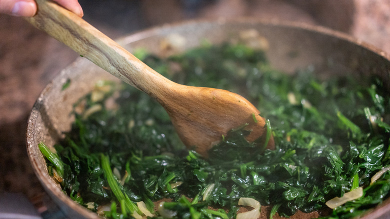 Stirring spinach in pan