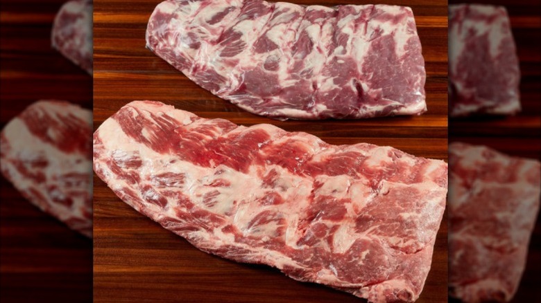 Two raw racks of ribs on a board