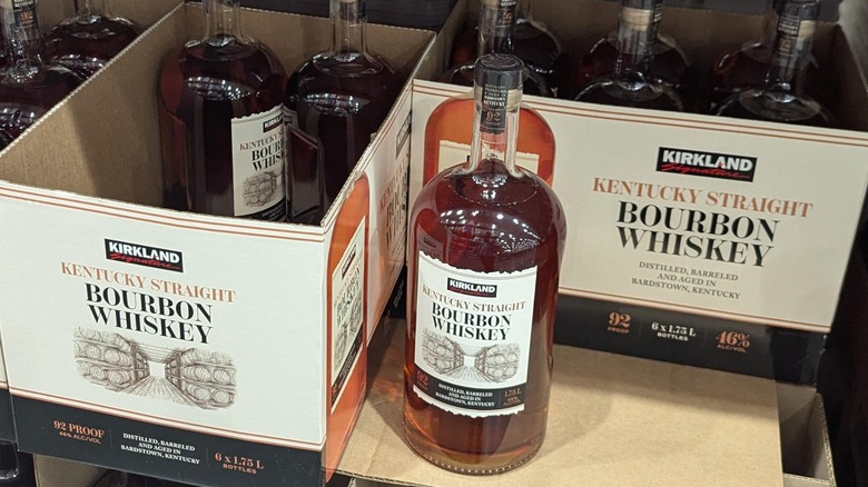 A bottle of Kirkland Signature Kentucky Straight Bourbon Whiskey next to boxes of the same