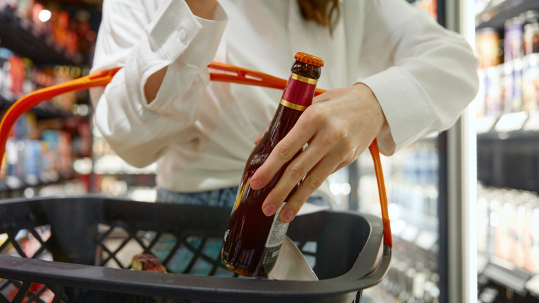 Woman placing beer bottle into basket