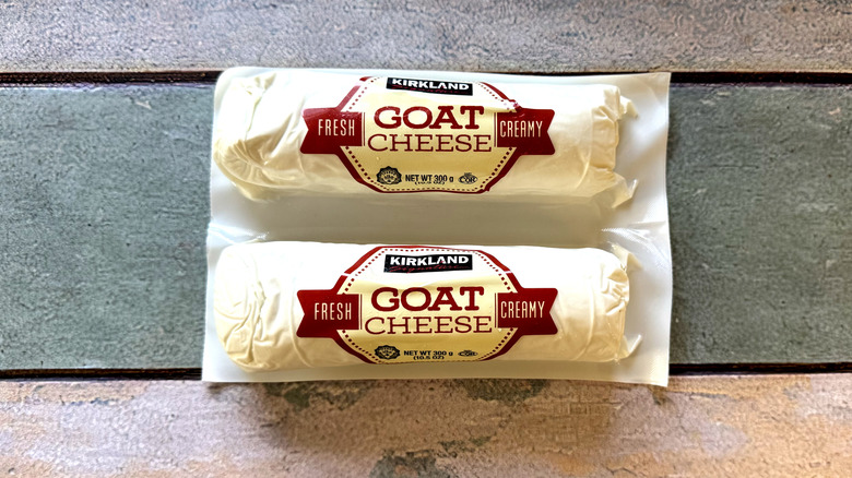 Two packaged logs of goat cheese on a table