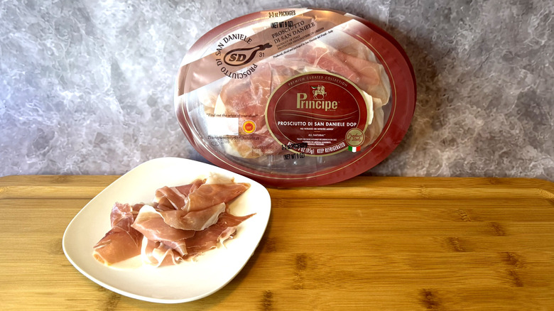 A plate of prosciutto with a package behind it