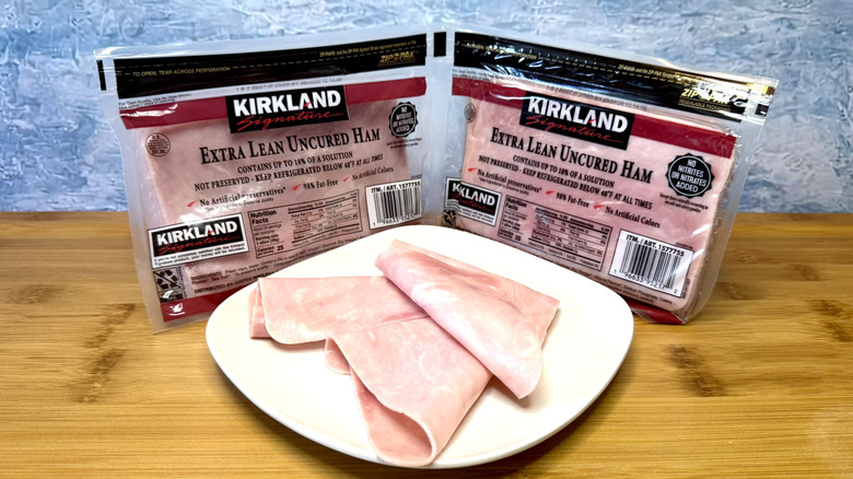 Sliced ham on a plate with packages behind