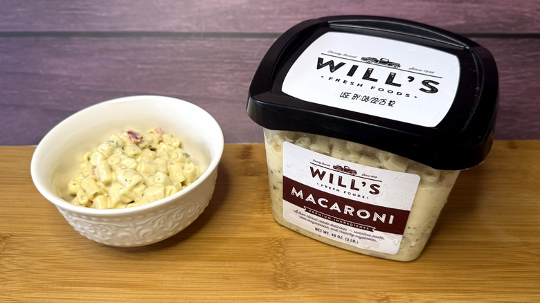 A container and bowl of macaroni salad