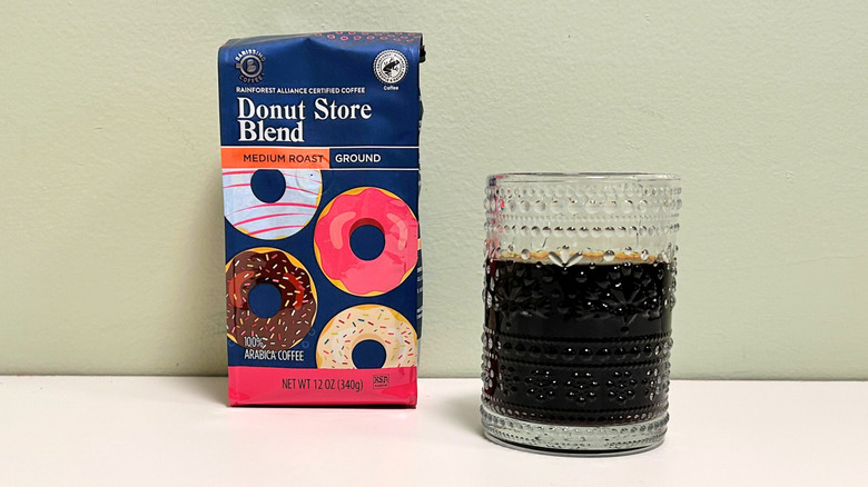 A glass cup filled with coffee next to a bag of Barrisimo Donut Store Blend