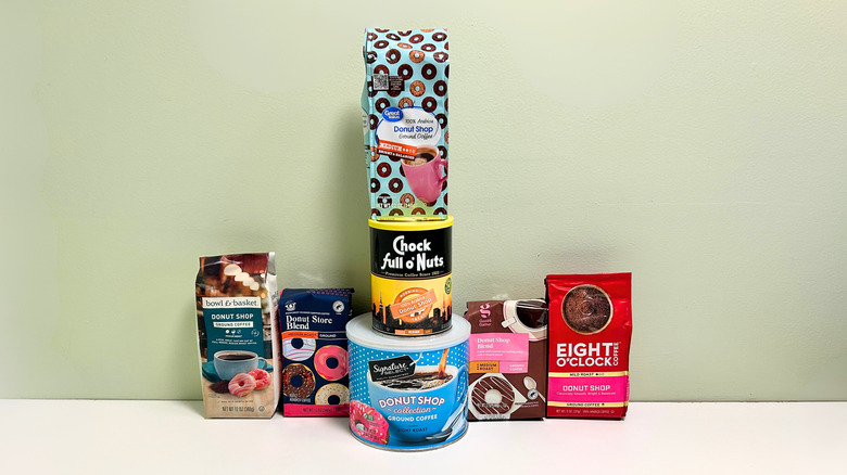 Seven brands of donut shop coffee lined up together against a green and white