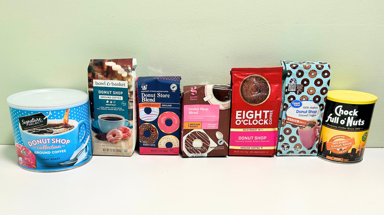 Seven brands of donut shop coffee lined up together against a green and white