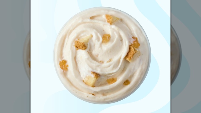A Dairy Queen Caramel Apple Cheesecake Blizzard on a striped blue background