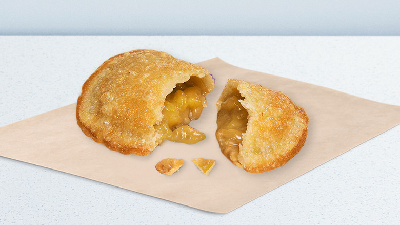 A split-open Taco Bell Caramel Apple Empanada on a wrapper