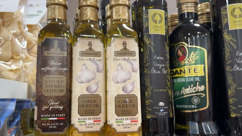 Assorted bottles of olive oil on a glass shelf