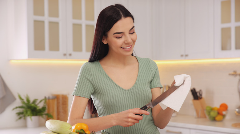 woman cleaning a large knife