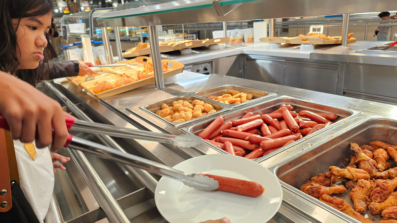 A young girl serves herself food at an IKEA food court