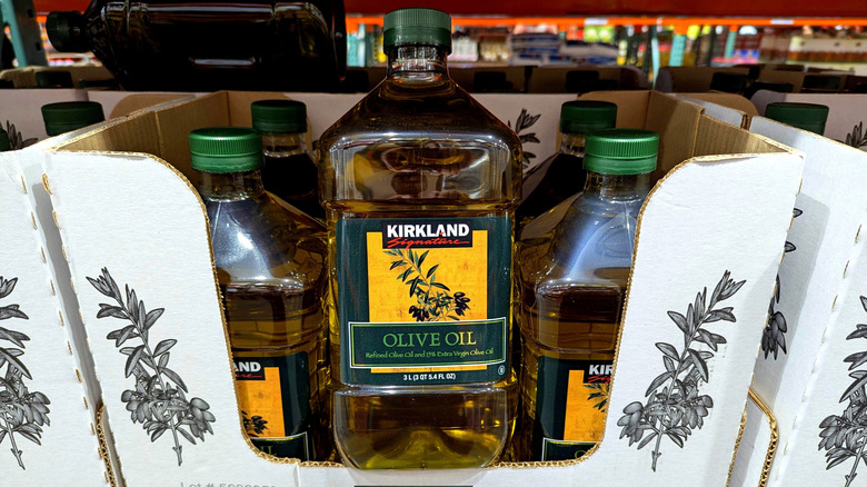 boxes of Kirkland Signature olive oil on grocery shelves