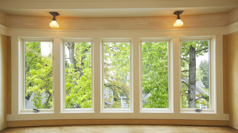 A large bay window with added light sconces hanging from the ceiling