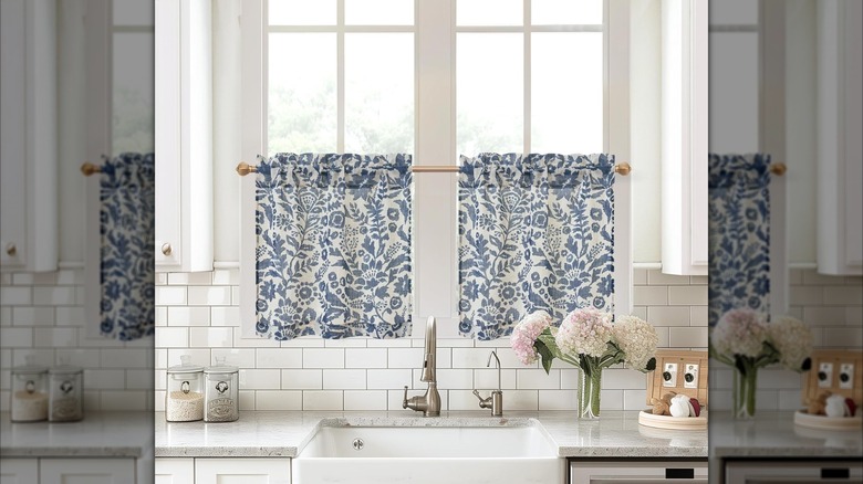 White cafe curtains with blue floral patterns in a kitchen window