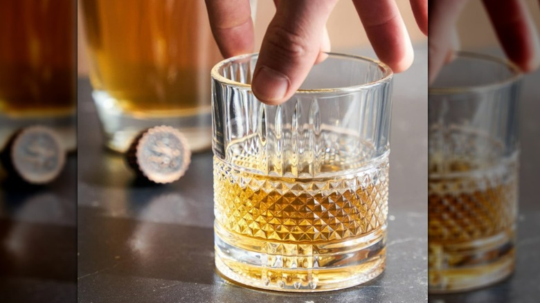 Person holding whiskey glass