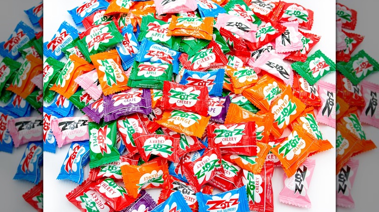 Various flavors of ZotZ candies in a pile on a white background