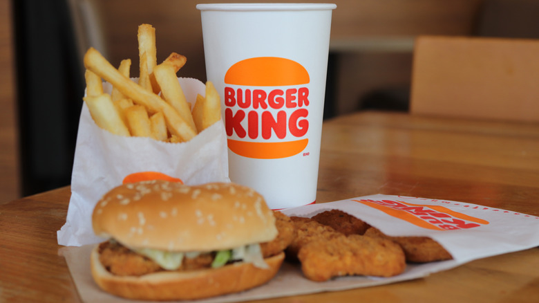 A Burger King chicken sandwich meal with nuggets, fries, and a fountain soda
