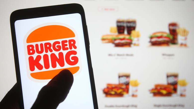 Burger King app on a phone with a menu screen in the background
