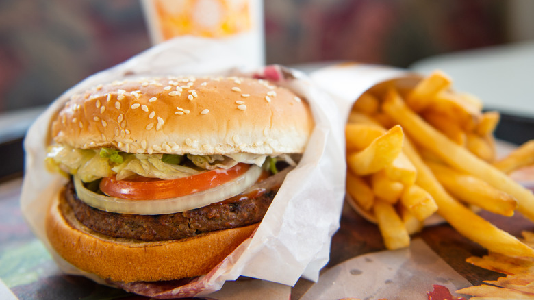 A Burger King Whopper on a sesame seed bun and french fries