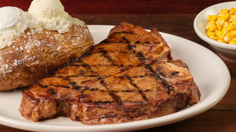 A Porterhouse T-Bone and baked potato on a white plate