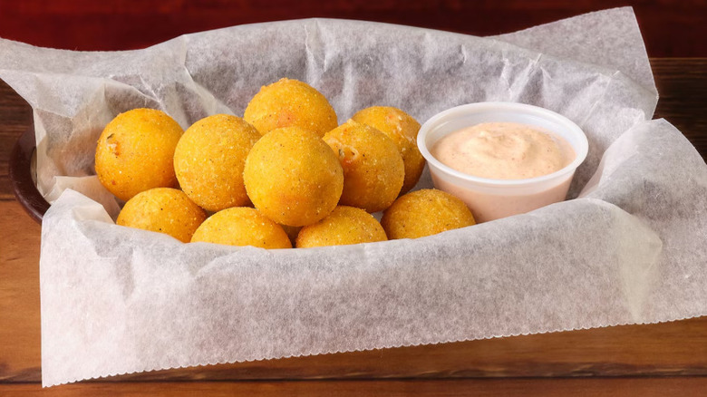 A basket of Texas Roadhouse Rattlesnake Bites with dipping sauce