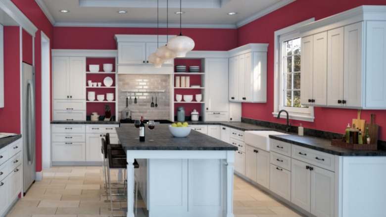 Kitchen with red walls, white cabinets, black countertops