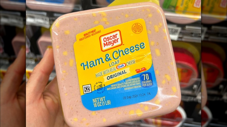 Person holding a package of Oscar Mayer ham and cheese loaf