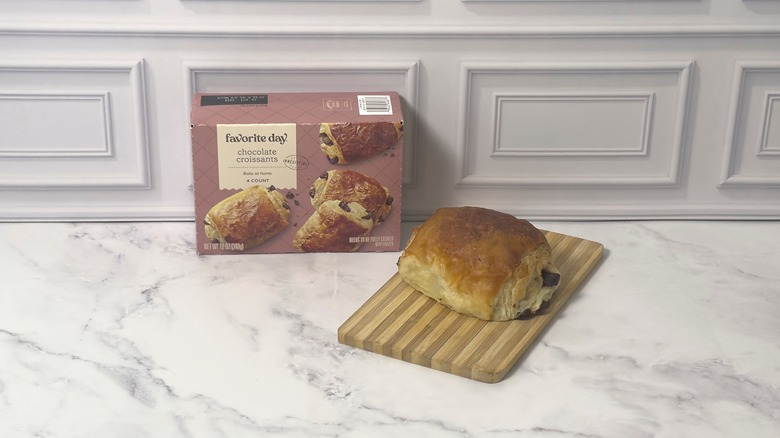Box of Target's Favorite Day chocolate croissants and a whole croissant on a wooden cutting board
