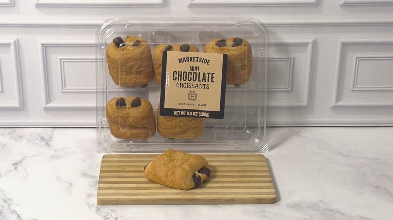 Package of Marketside mini chocolate croissants from Walmart and a whole croissant on a wooden cutting board