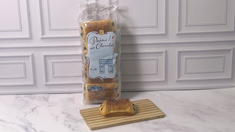 Package of L'oven Fresh chocolate croissants from Aldi and one croissant on a wooden cutting board