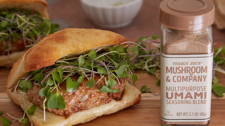 Umami seasoning bottle next to sandwich that is packed with greens