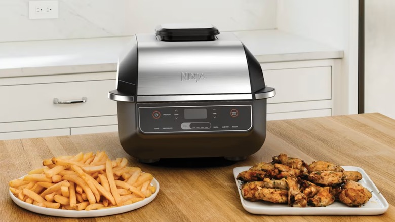 Ninja Foodi Indoor Grill and Air Fryer with a plate of fries and chicken
