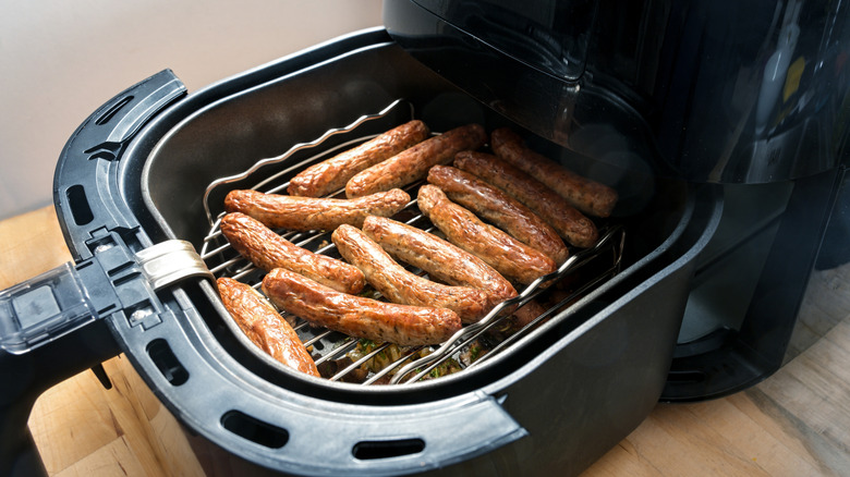 Sausage links lined on a rack in a basket air fryer