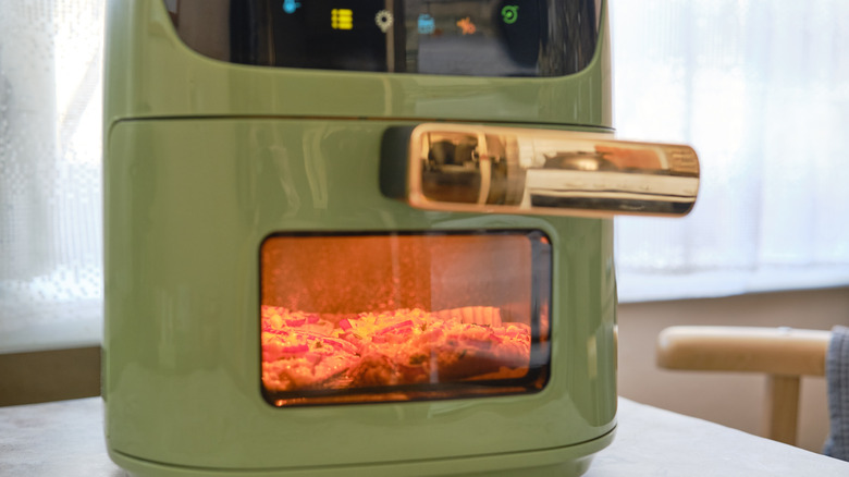 Green air fryer with a window and internal light