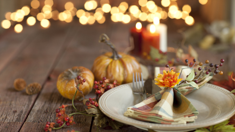 autumn themed table setting with ferry lights, napkin rings, and candles