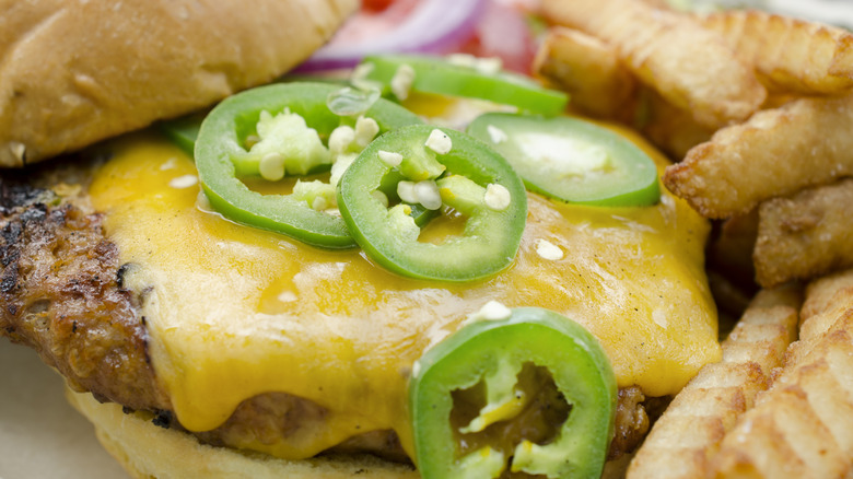 Jalapeño slices on cheeseburger with fries