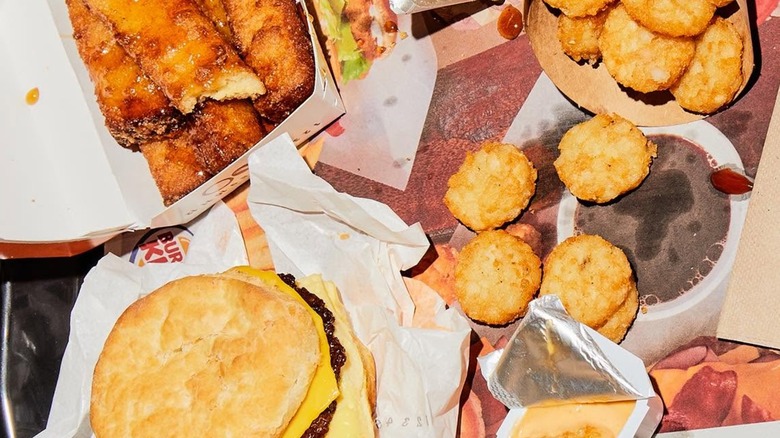 A Burger King breakfast meal with a biscuit sandwich, hash browns, and French toast sticks
