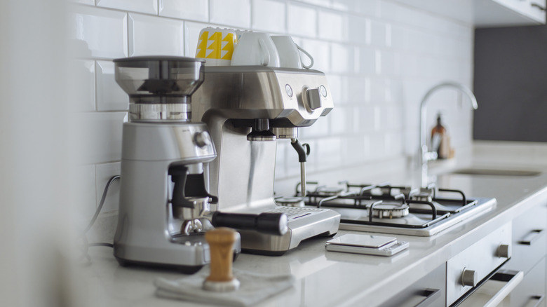 Espresso machine and coffee grinder on modern home kitchen counter