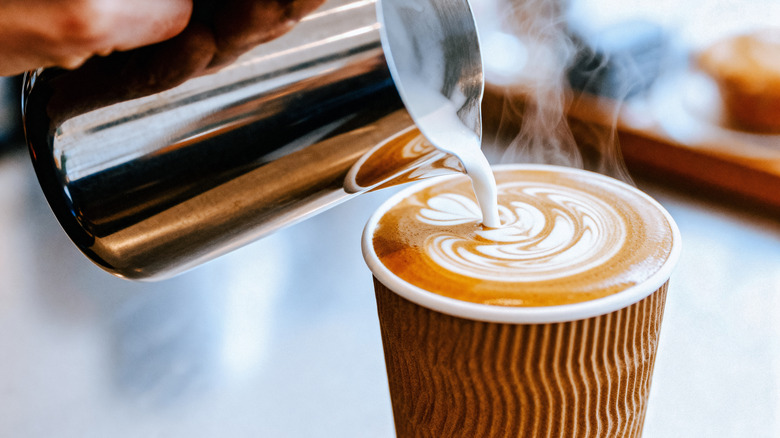 Steamed milk pouring into a latte, creating latte art