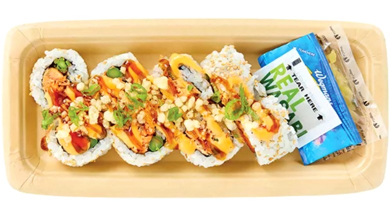 8 pieces of teriyaki salmon roll with white rice with packets of wasabi and soy sauce on the side