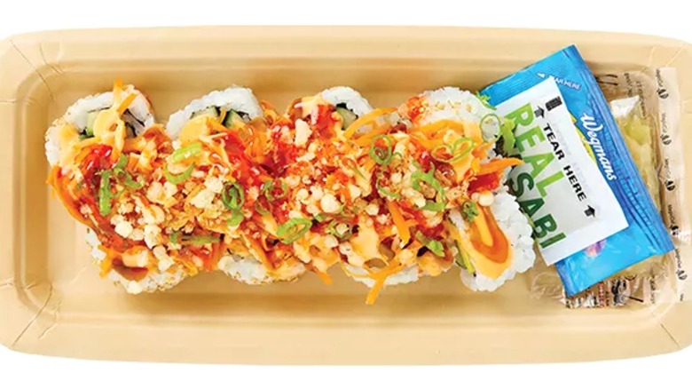 8 pieces of sushi with garnish on top and sauce in packets on the side