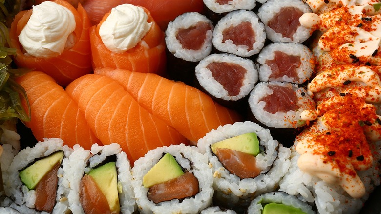 An assorted sushi platter including nigiri, salmon, and avocado and tuna rolls
